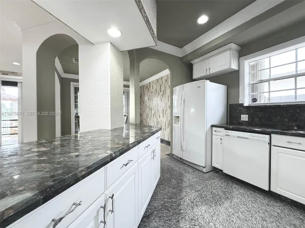 a large white kitchen with a large window