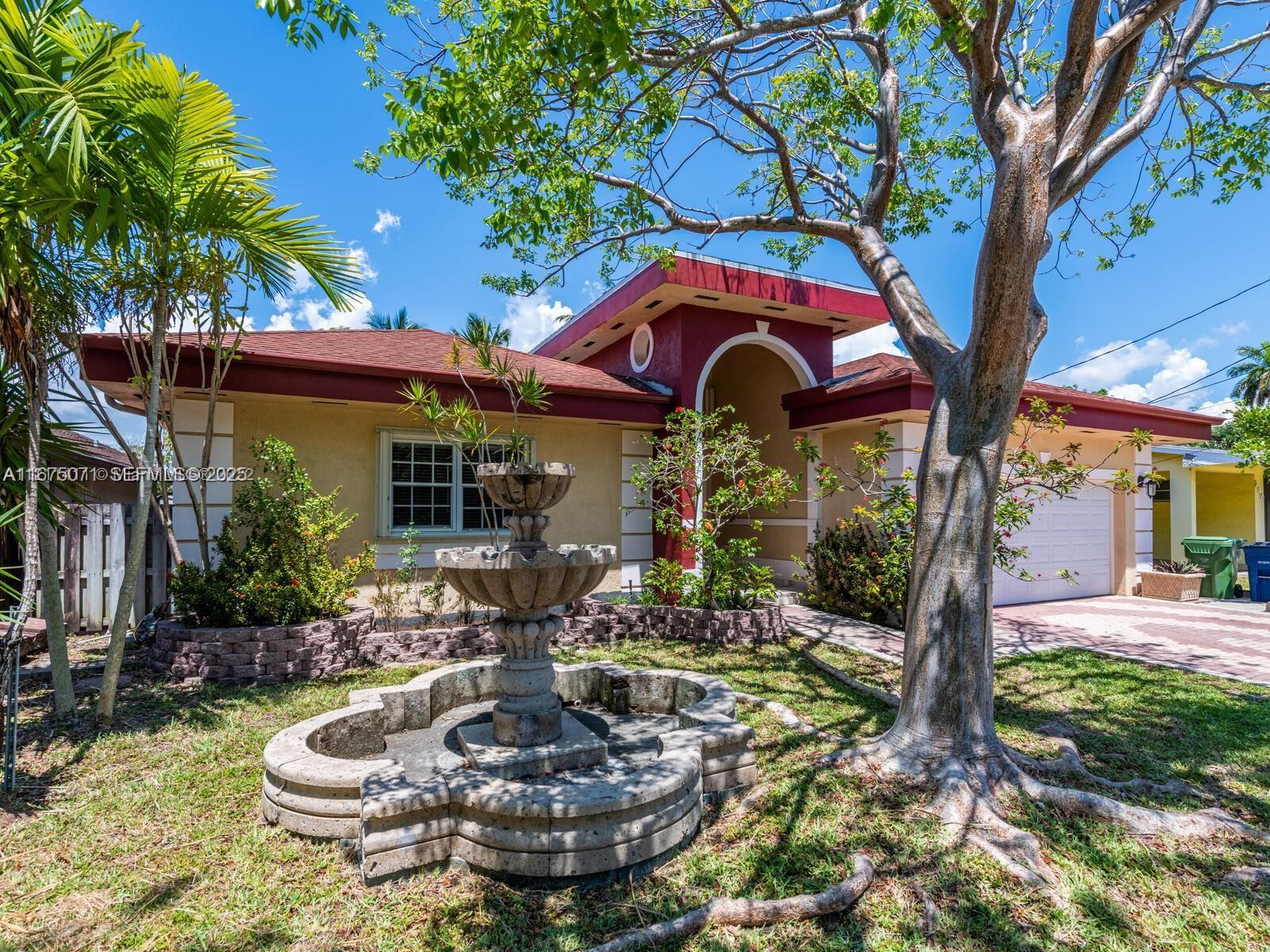 232 Southwest 7th Avenue Hallandale Beach, FL 33009 - Photo 8 of 48 a front view of a house with garden and patio