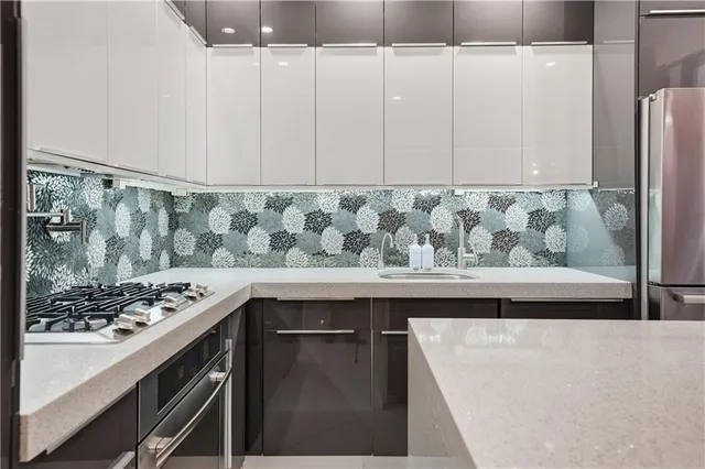 a view of kitchen island with stainless steel appliances granite countertop a sink and a stove