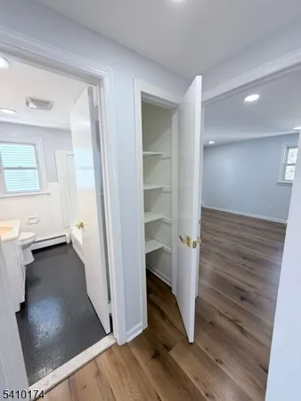 wooden floor & ceiling fan in a bathroom