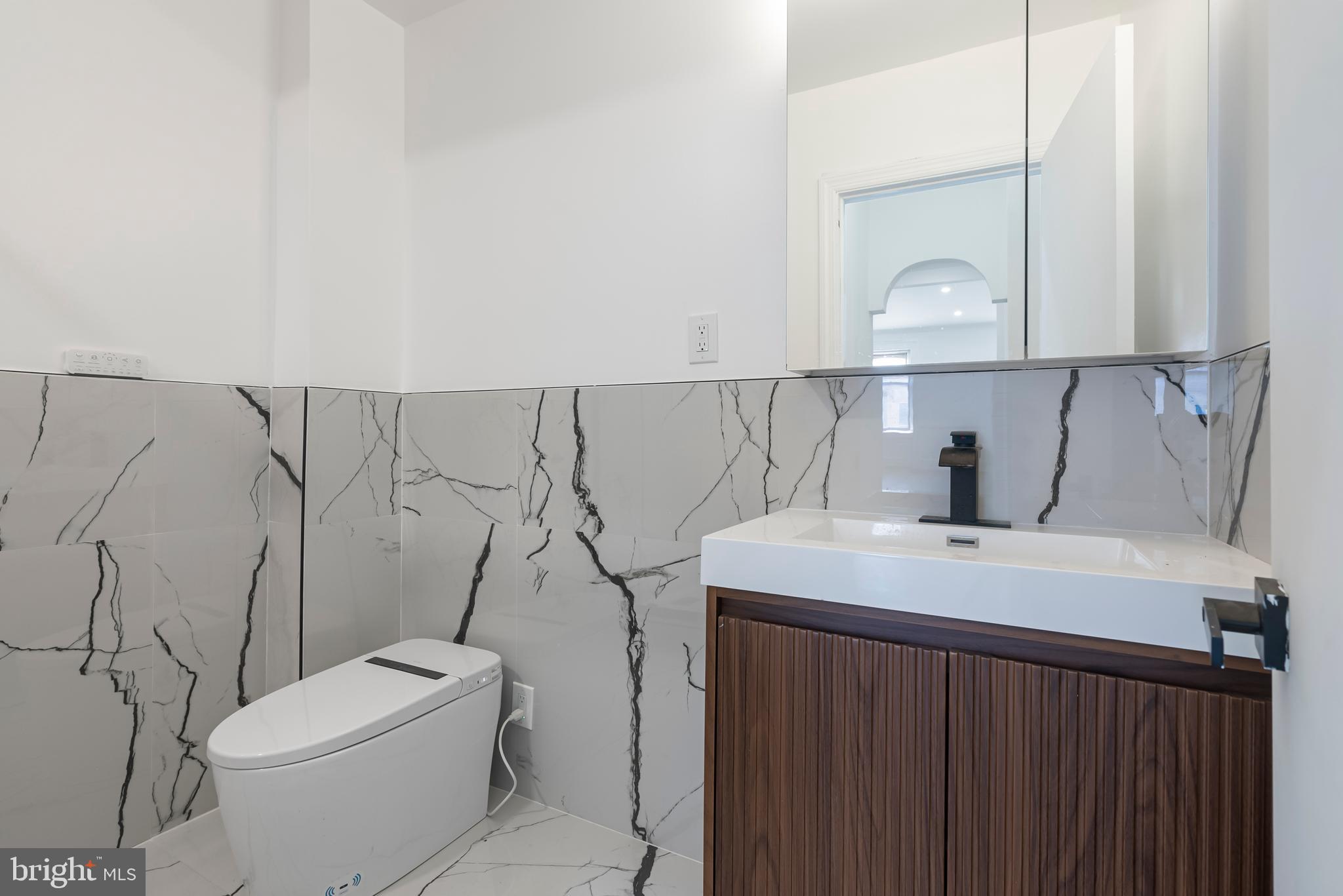 1618 South Broad Street Philadelphia, PA 19145 - Photo 13 of 27 a bathroom with a sink a toilet and a mirror