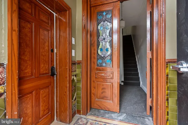 an empty room with wooden floor fireplace and windows