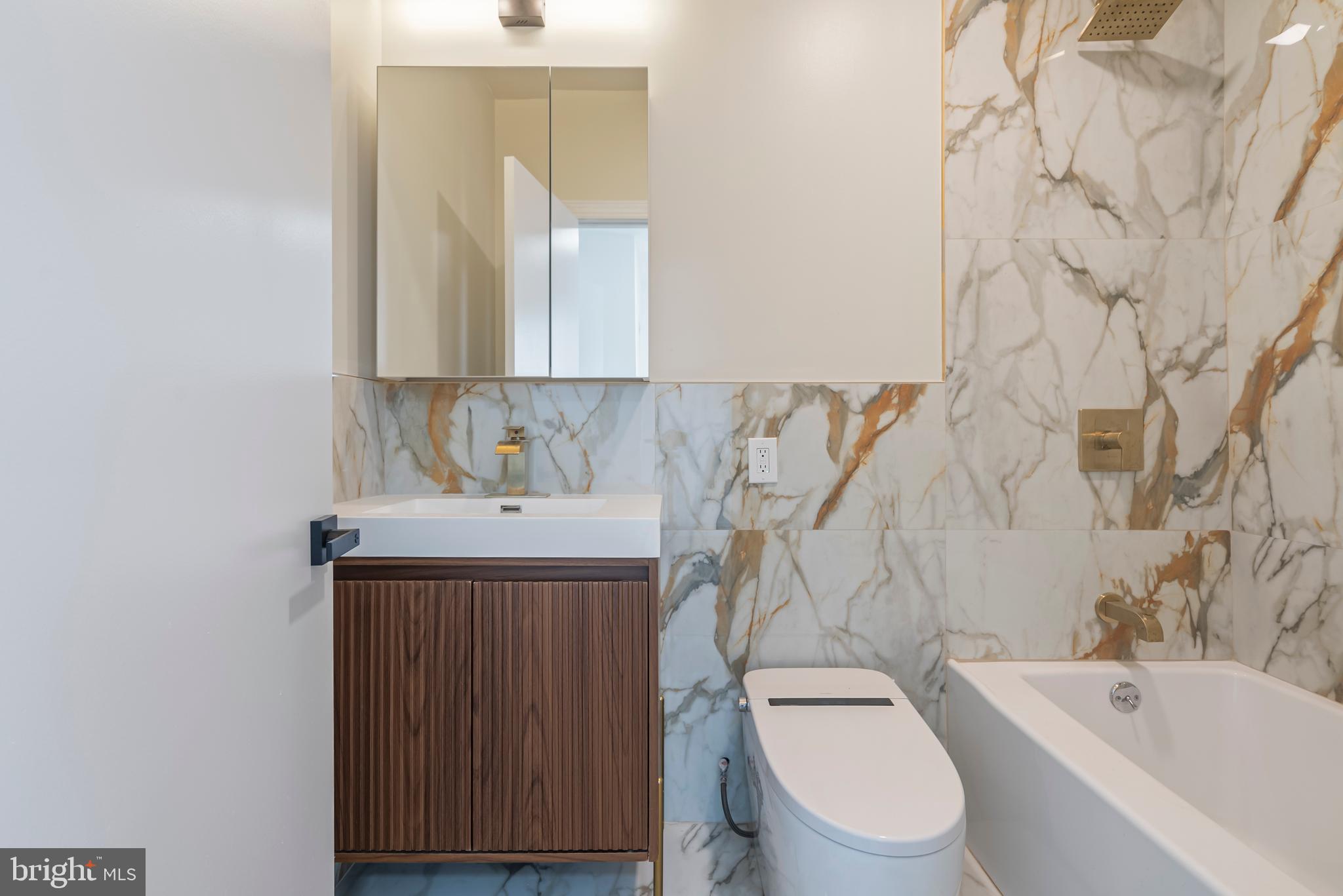 1618 South Broad Street Philadelphia, PA 19145 - Photo 23 of 27 a bathroom with a toilet sink vanity tub and mirror