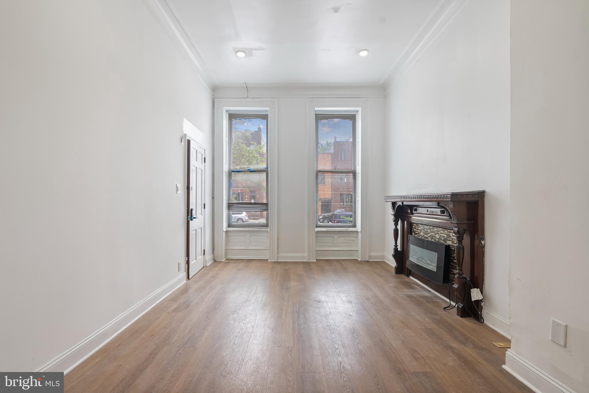 1618 South Broad Street Philadelphia, PA 19145 - Photo 3 of 27 an empty room with wooden floor fireplace and windows