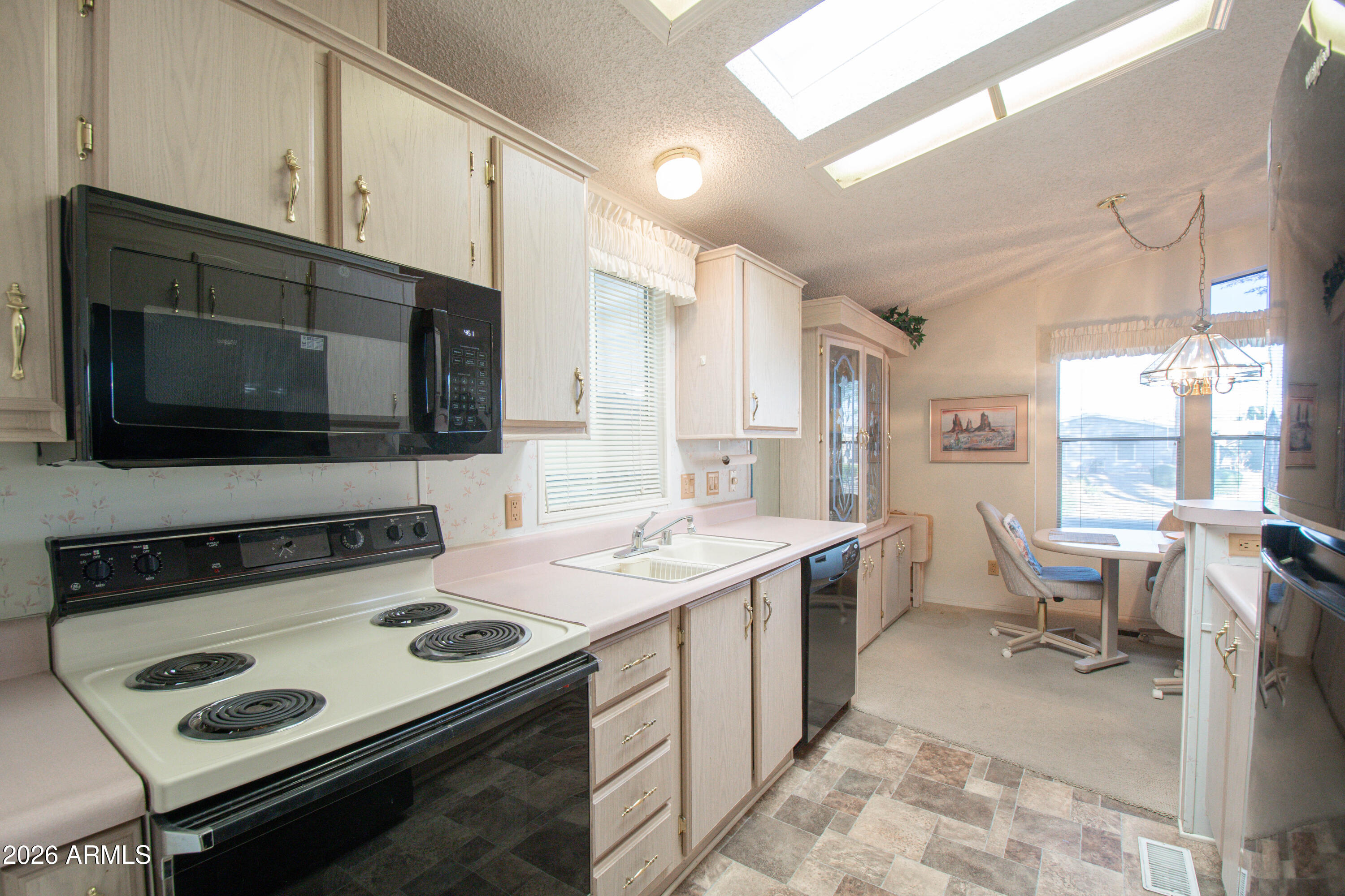 5735 East McDowell Road, Unit 26 Mesa, AZ 85215 - Photo 13 of 39 a kitchen with a stove a sink and a microwave