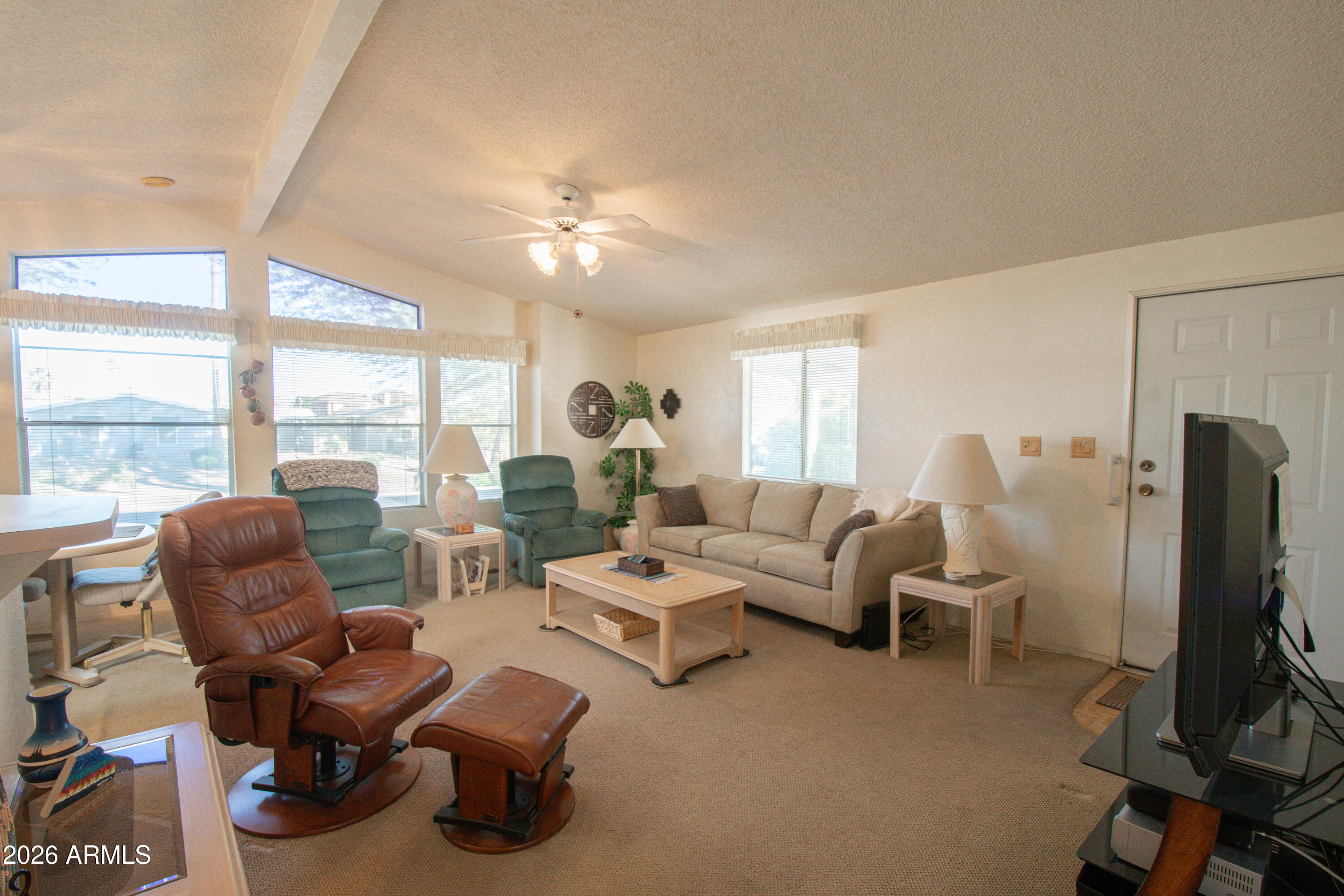 5735 East McDowell Road, Unit 26 Mesa, AZ 85215 - Photo 4 of 39 a living room with furniture ceiling fan and a large window