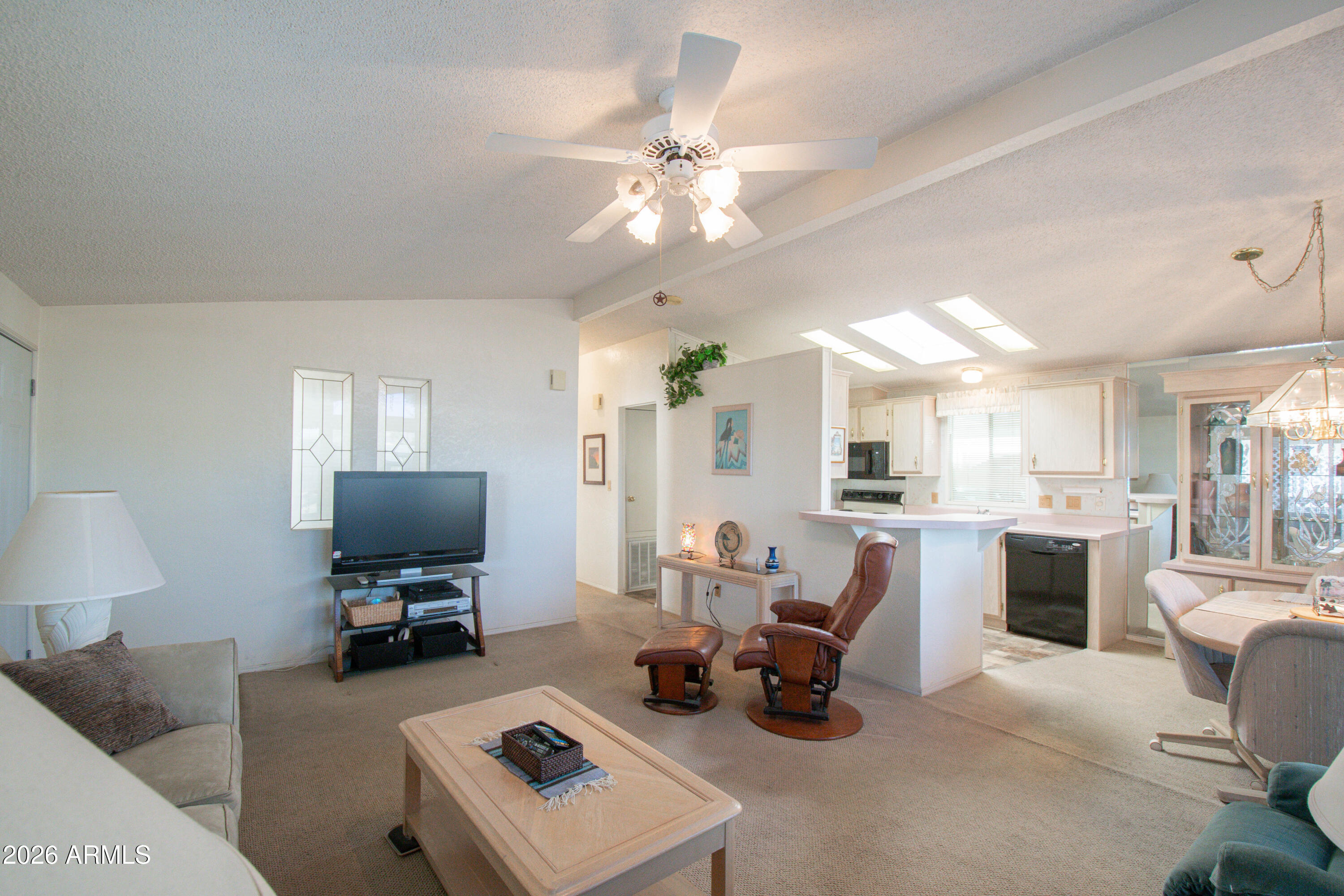 5735 East McDowell Road, Unit 26 Mesa, AZ 85215 - Photo 6 of 39 a living room with furniture a chandelier and a flat screen tv