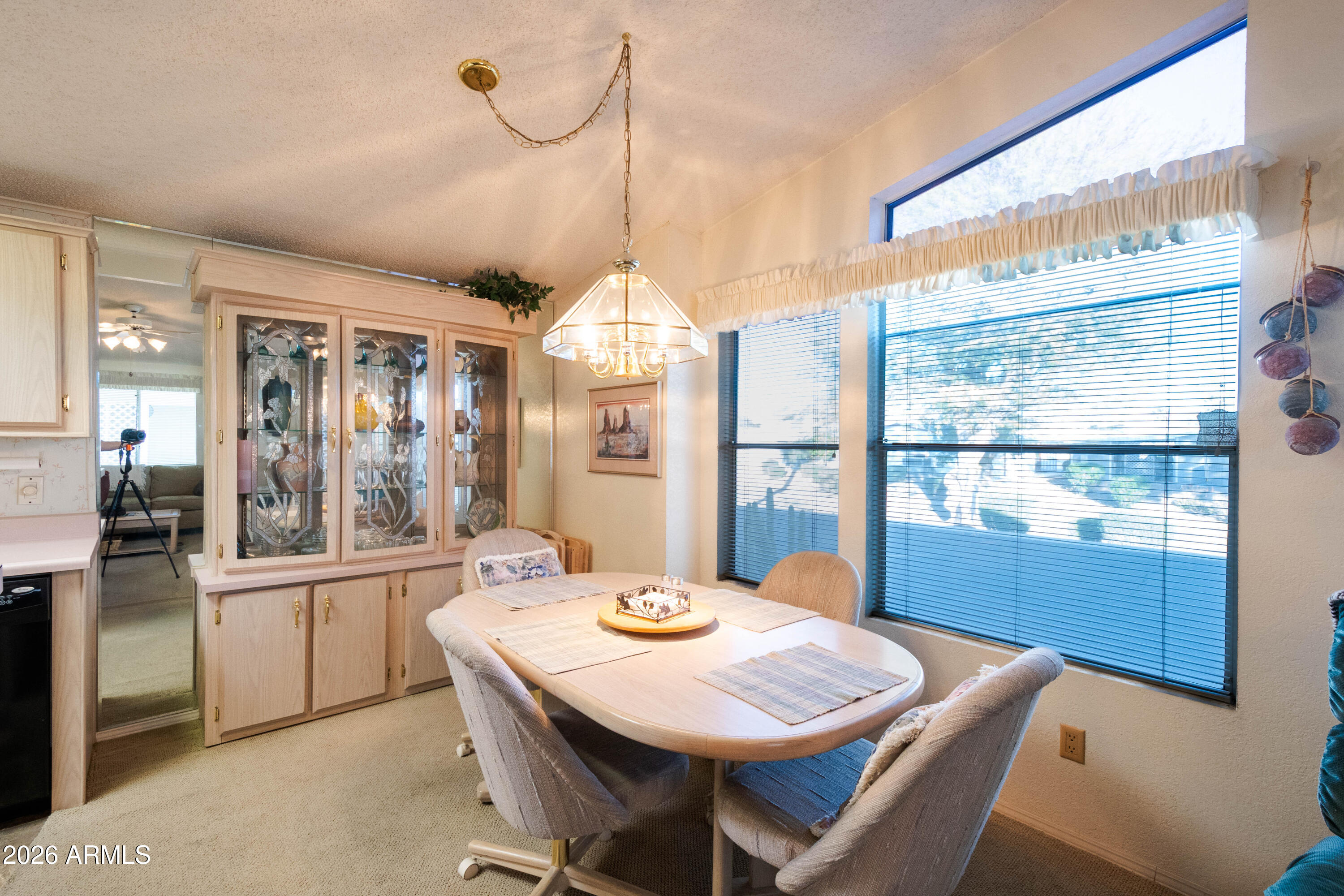 5735 East McDowell Road, Unit 26 Mesa, AZ 85215 - Photo 7 of 39 a dining room with furniture a chandelier and wooden floor