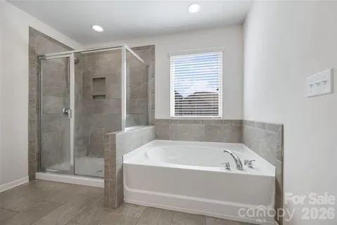 a white bath tub sitting next to a shower
