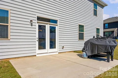 a view of a patio with a table and chairs and a barbeque