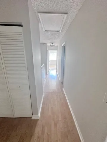 a view of a hallway with wooden floor
