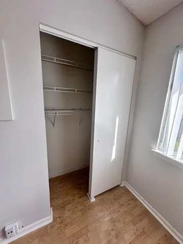 an empty room with closet and windows