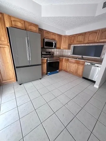 a kitchen with stainless steel appliances a refrigerator sink and microwave