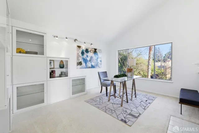 a living room with furniture a dining table and paintings on the wall