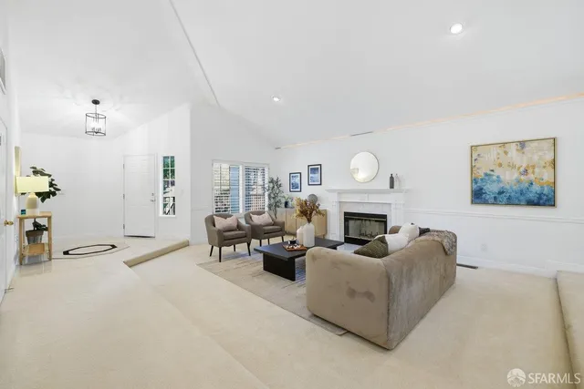 a living room with furniture a fireplace and a potted plant