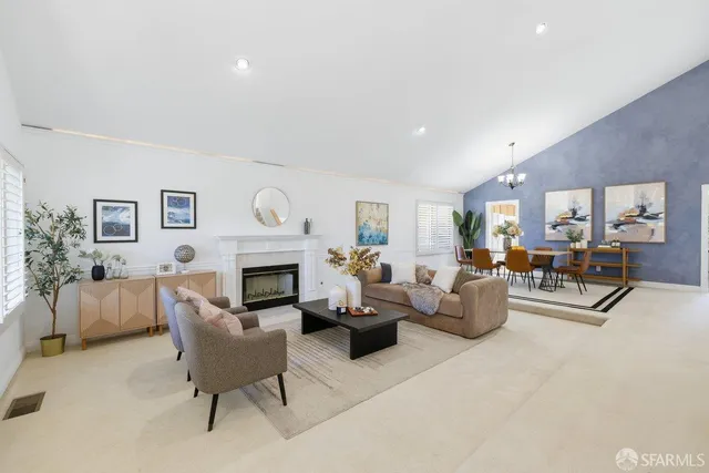 a living room with furniture a fireplace and a potted plant