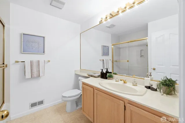 a bathroom with a sink a toilet and a large mirror