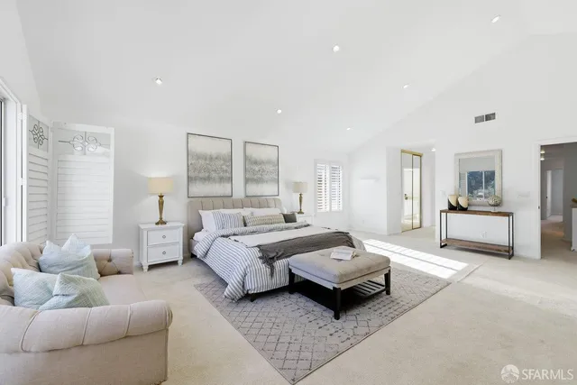 a spacious bedroom with a bed couch and window