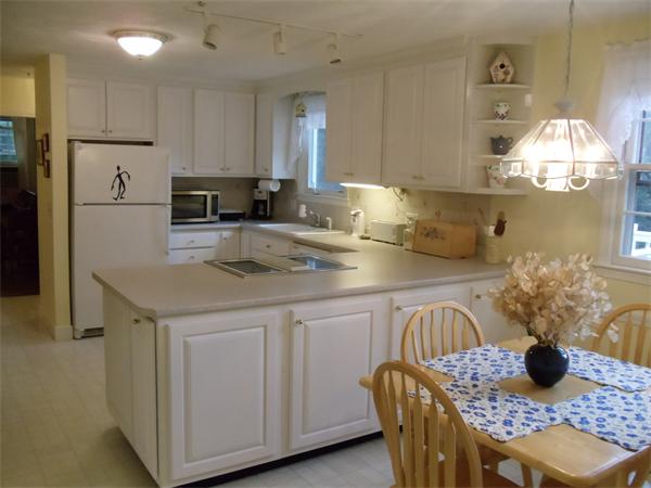 39 Barton Road Stow, MA 01775 - Photo 5 of 14 a kitchen with stainless steel appliances granite countertop a table chairs and a refrigerator