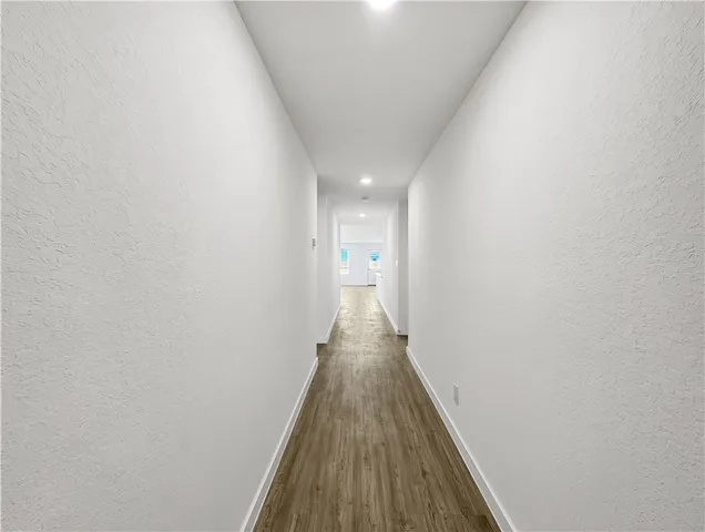 a view of a hallway with wooden floor