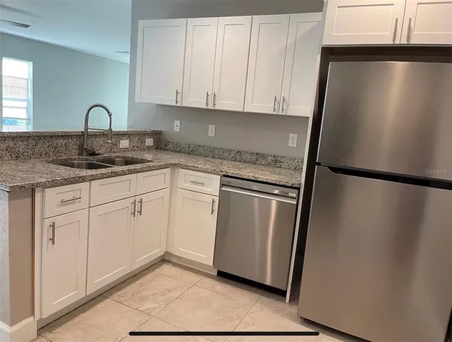 a bathroom with a granite countertop bathtub sink vanity mirror and toilet