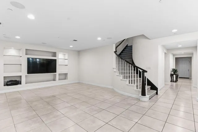 a view of an entryway with wooden floor and livingroom