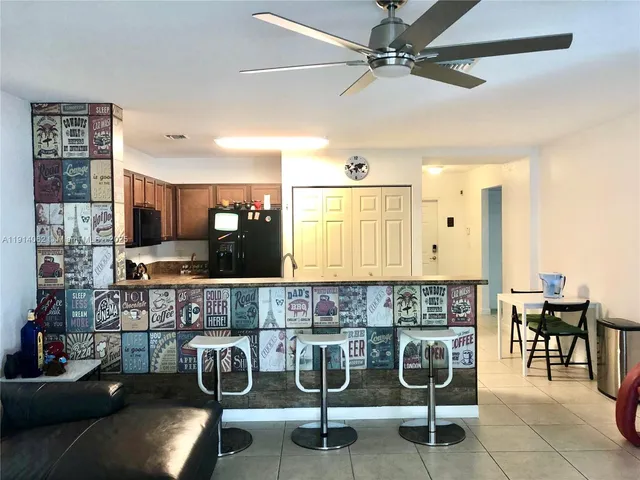 a kitchen with stainless steel appliances kitchen island granite countertop a cabinets and chairs