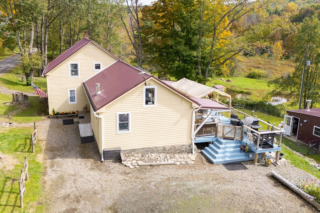 1668 Vandervort Hill Road Unadilla, NY 13849 - Photo 2 of 50 An elevated perspective showcases the multi-level metal roofline and sprawling backyard wood deck.