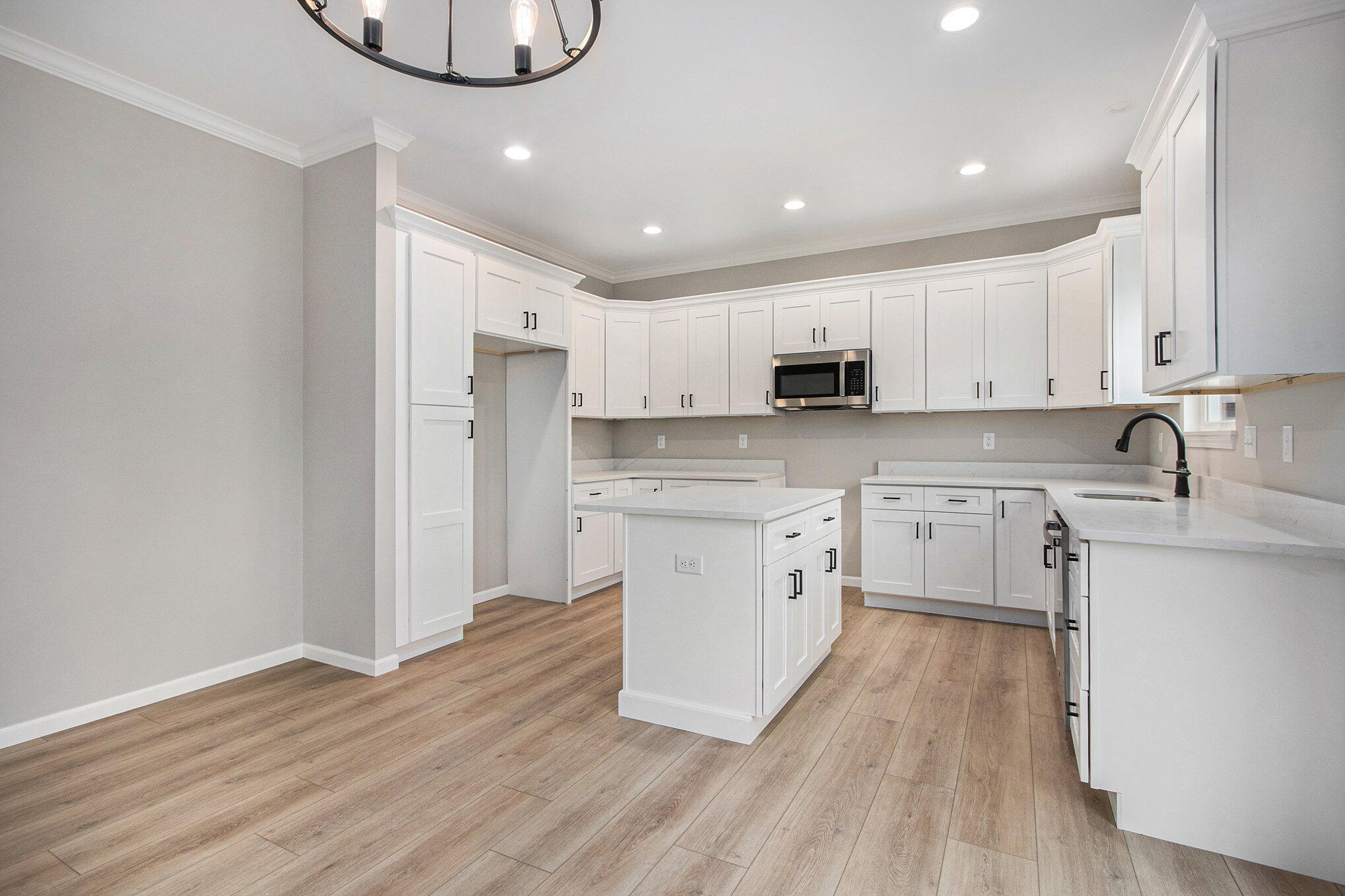 5766 Brookview Avenue Portage, IN 46368 - Photo 7 of 18 a kitchen with white cabinets stainless steel appliances and wooden floor