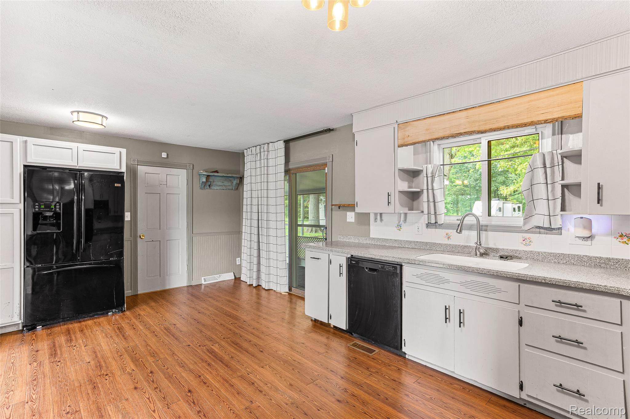 9561 Exeter Road Carleton, MI 48117 - Photo 17 of 46 Wood-finish flooring with white cabinetry and a black appliance package