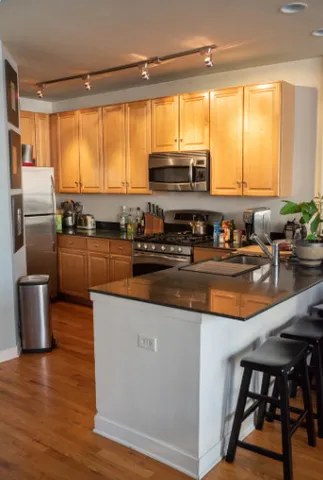 a kitchen with stainless steel appliances a stove top oven a sink and a refrigerator