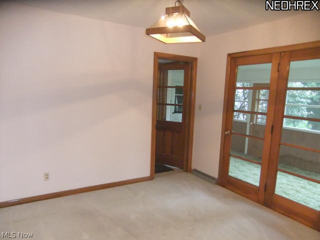 2141 Coon Road Akron, OH 44321 - Photo 7 of 16 This room could be used as a den or 3rd bedroom. This room features, single closet, neutral decor, and french doors to the sunroom.