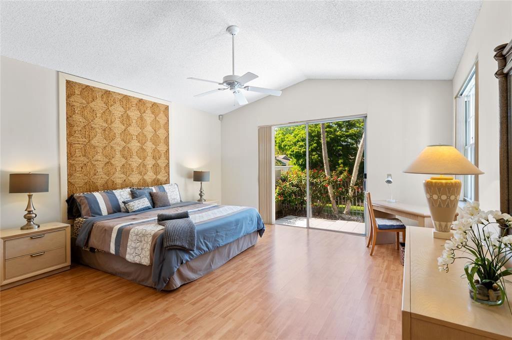 8170 Hampton Wood Drive Boca Raton, FL 33433 - Photo 10 of 21 a spacious bedroom with a bed chandelier and a window