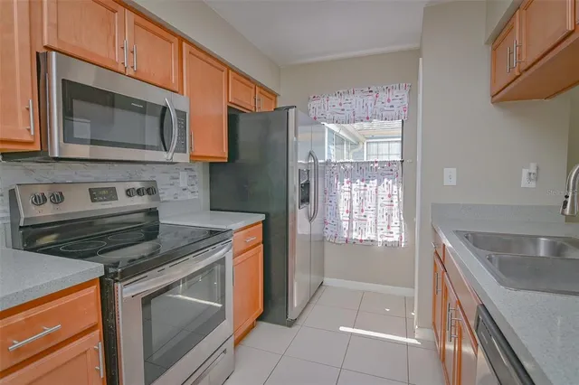 a kitchen with stainless steel appliances granite countertop a stove microwave and sink