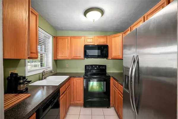 a kitchen with stainless steel appliances granite countertop a sink a stove and a refrigerator