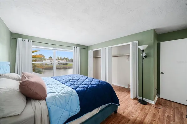 a bedroom with a bed and a wooden floor