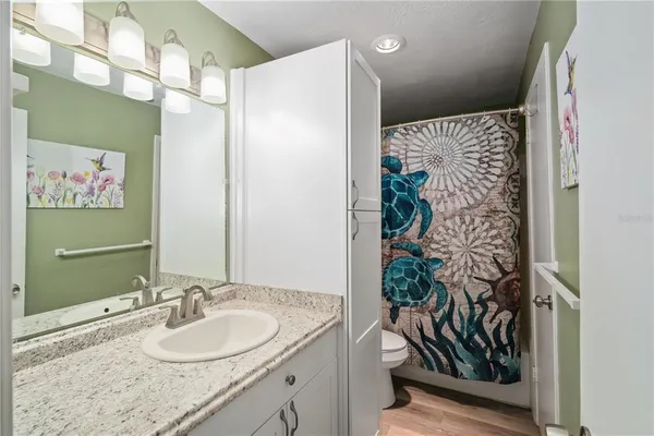 a bathroom with a granite countertop sink a large mirror and a shower