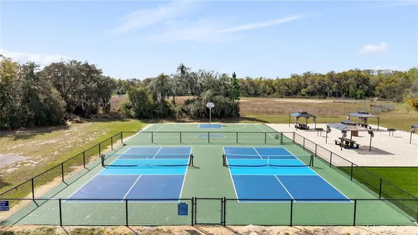 a view of swimming pool with seating area and trees in the background