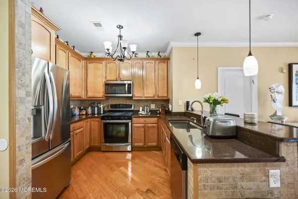 a kitchen with stainless steel appliances granite countertop a sink refrigerator and microwave