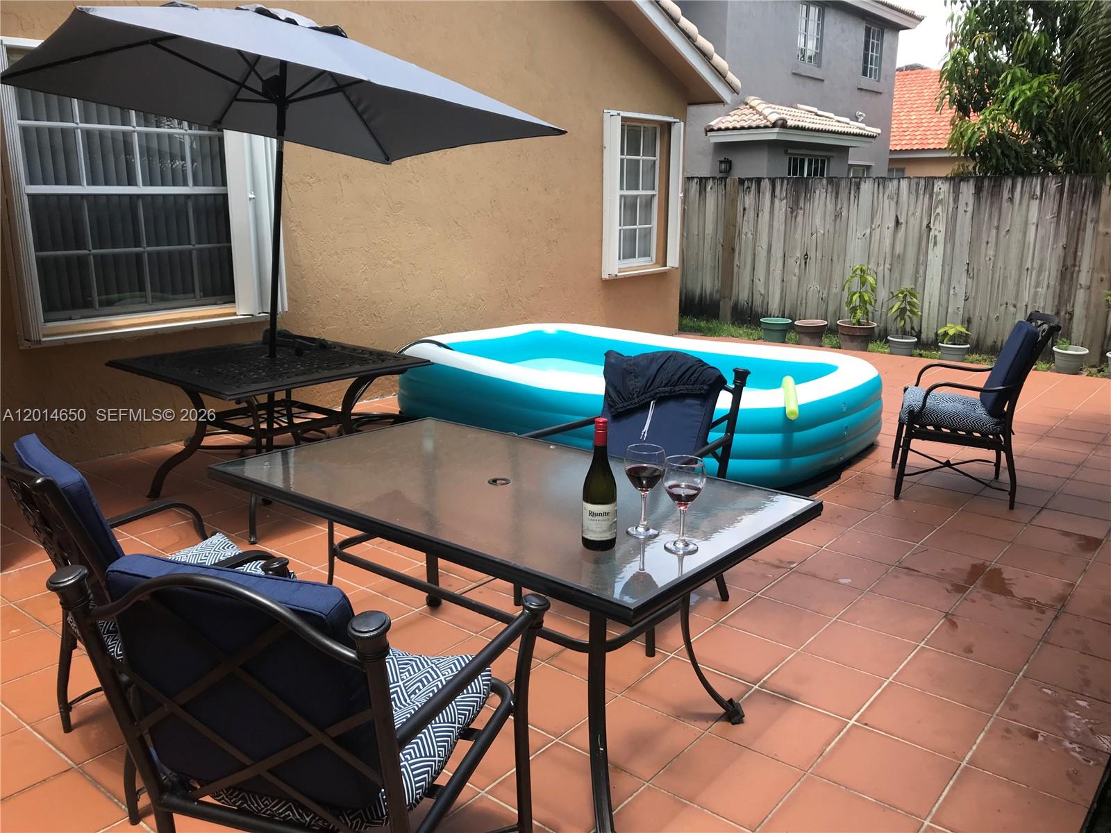 16654 Southwest 103rd Lane Miami, FL 33196 - Photo 19 of 20 a backyard of a house with table and chairs
