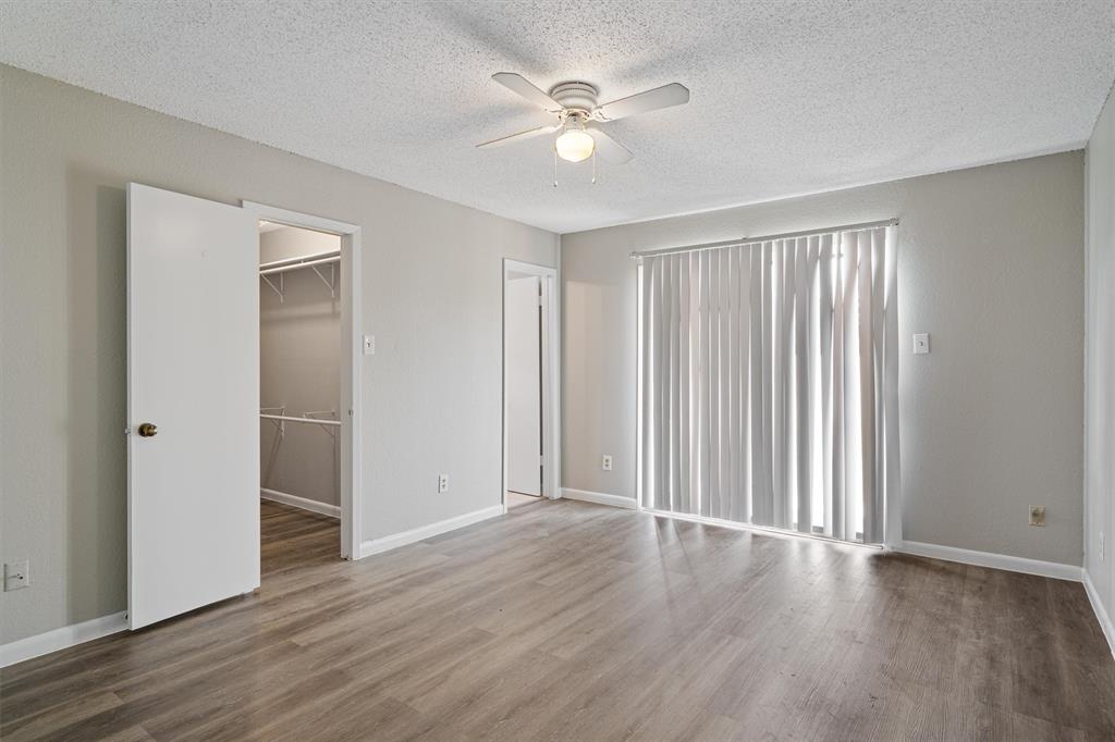 13357 Water Oak Lane, Unit B Austin, TX 78729 - Photo 12 of 26 an empty room with wooden floor and a ceiling fan