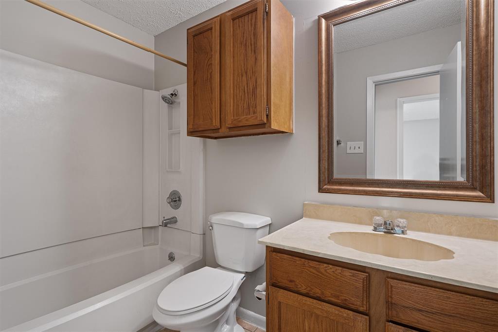 13357 Water Oak Lane, Unit B Austin, TX 78729 - Photo 19 of 26 a bathroom with a granite countertop sink toilet and mirror
