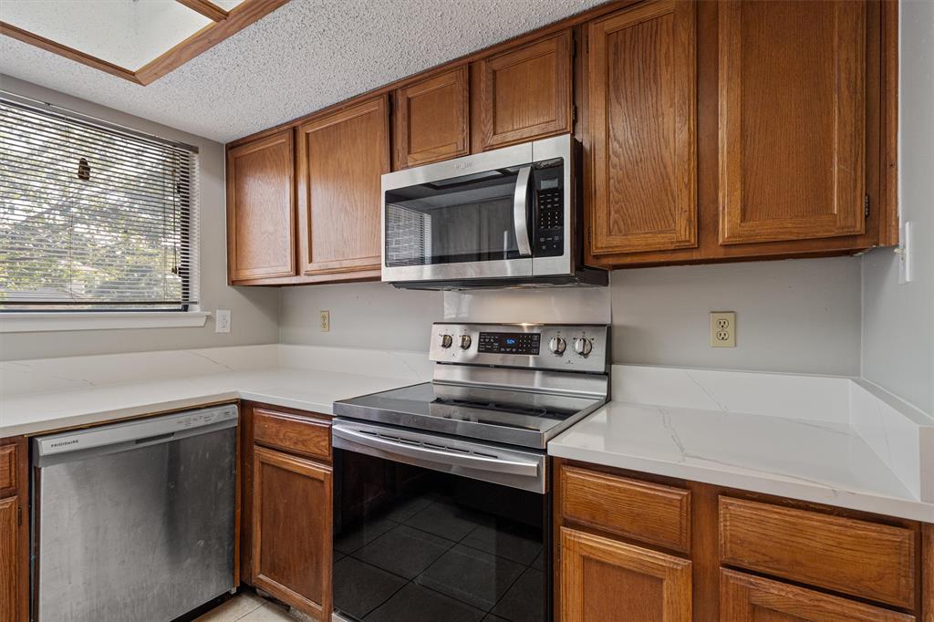 13357 Water Oak Lane, Unit B Austin, TX 78729 - Photo 9 of 26 a kitchen with wooden cabinets and a stove top oven