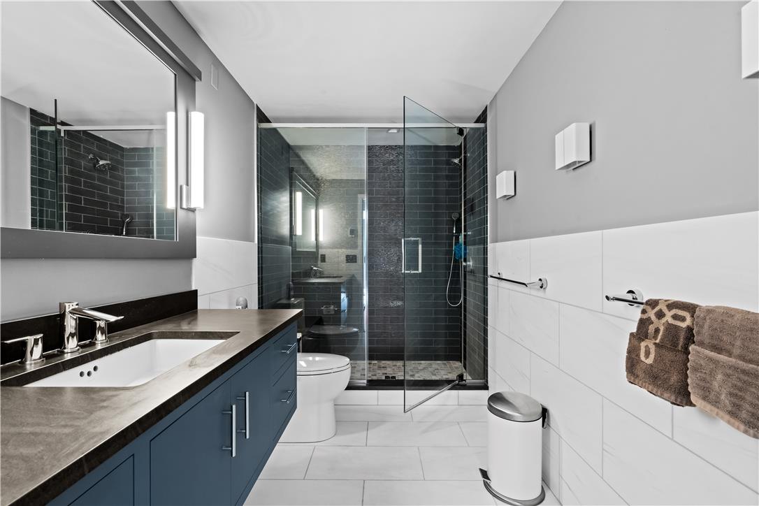 1506 Pleasant View Road Coopersburg, PA 18036 - Photo 70 of 97 A well-lit contemporary bathroom boasts a vanity with a sleek countertop and a glass-enclosed shower.