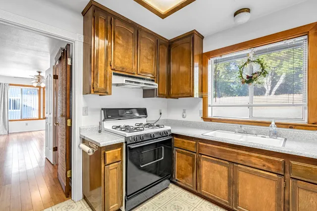 a view of a livingroom with wooden floor and a ceiling fan