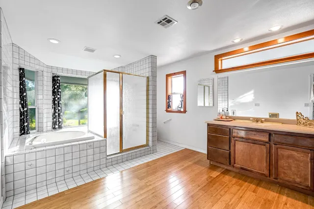 an aerial view of residential house with outdoor space and trees all around