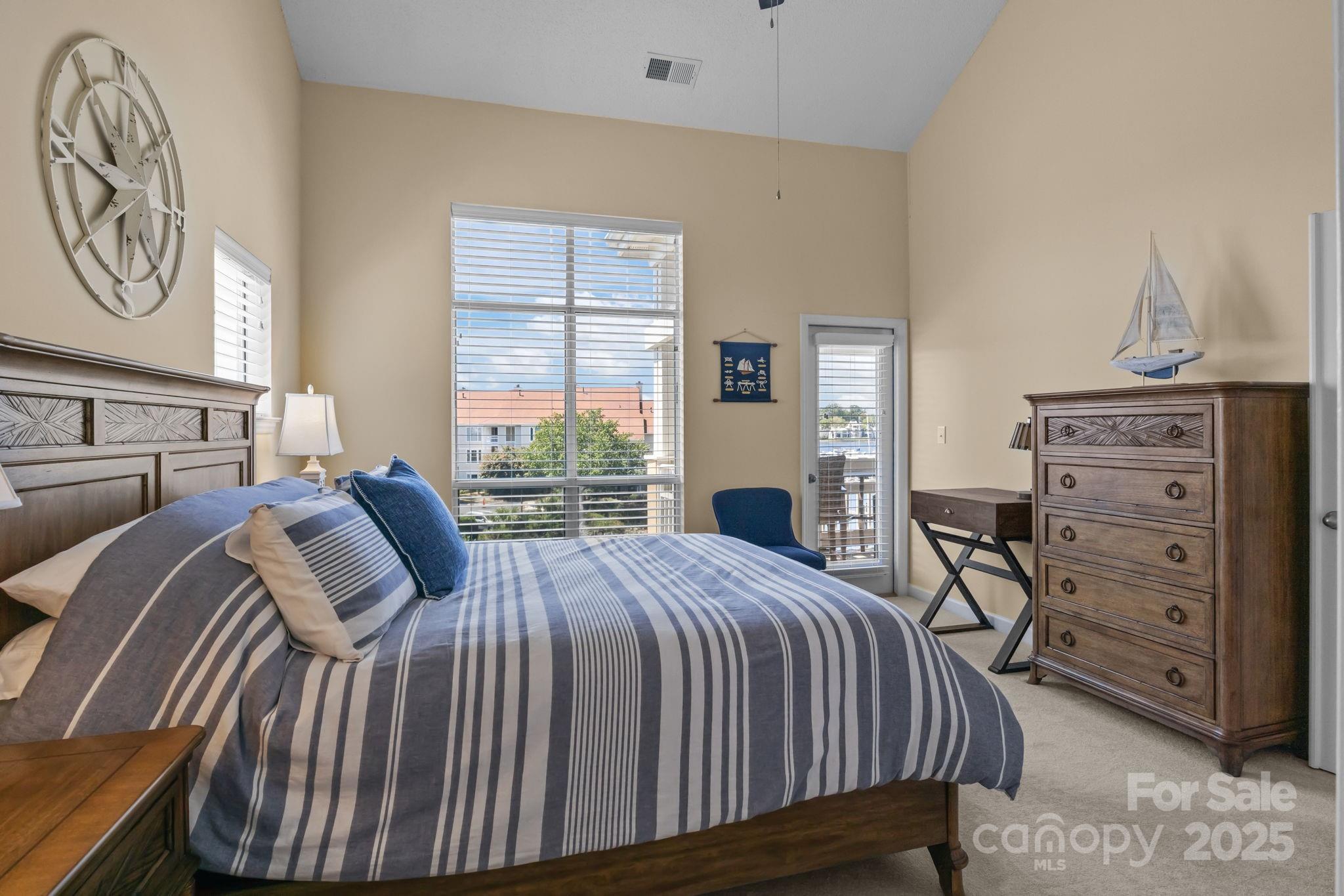 18009 Kings Point Drive, Unit I Cornelius, NC 28031 - Photo 20 of 47 a bedroom with a bed a dresser and chair