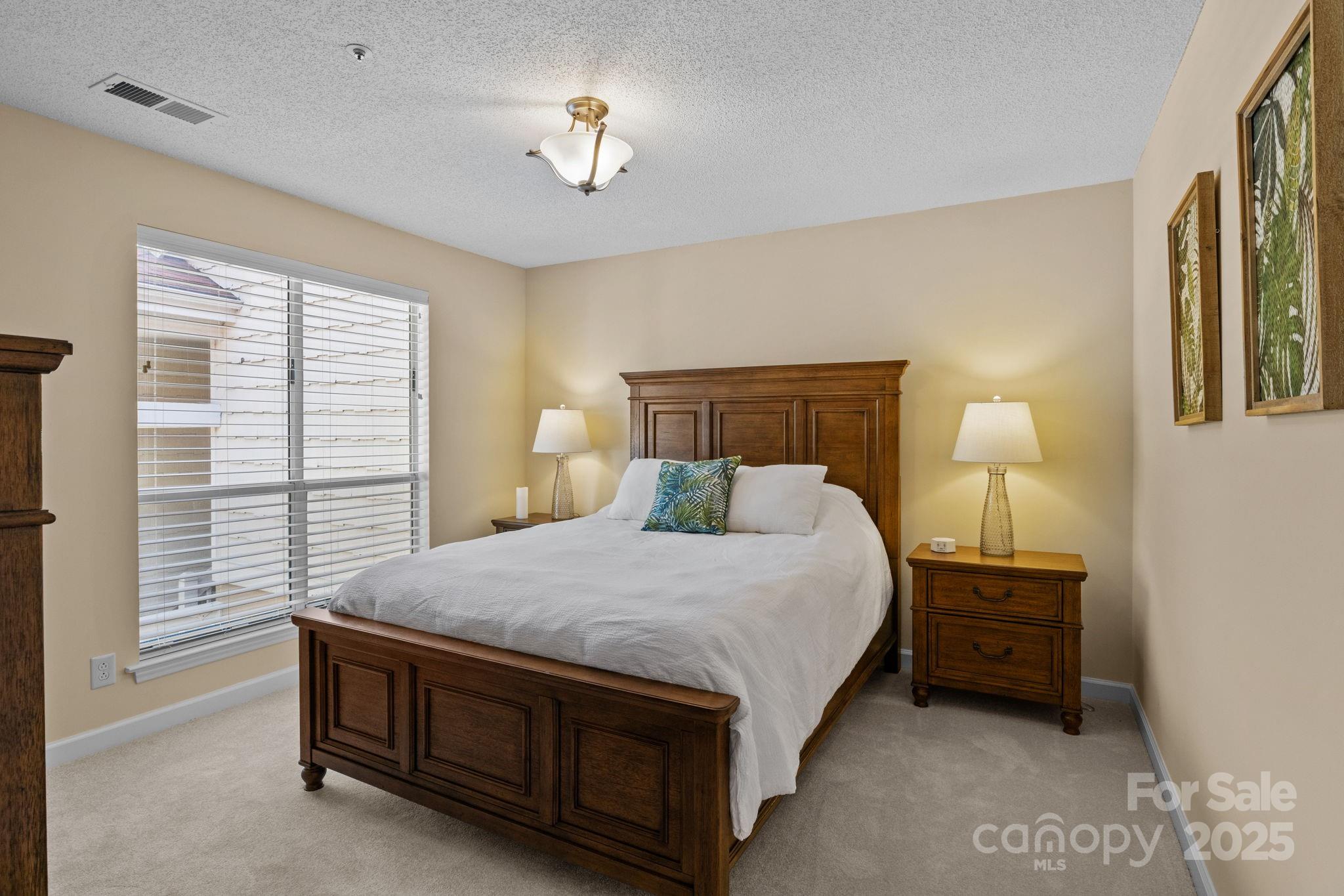 18009 Kings Point Drive, Unit I Cornelius, NC 28031 - Photo 24 of 47 a bedroom with a bed a chandelier and a window