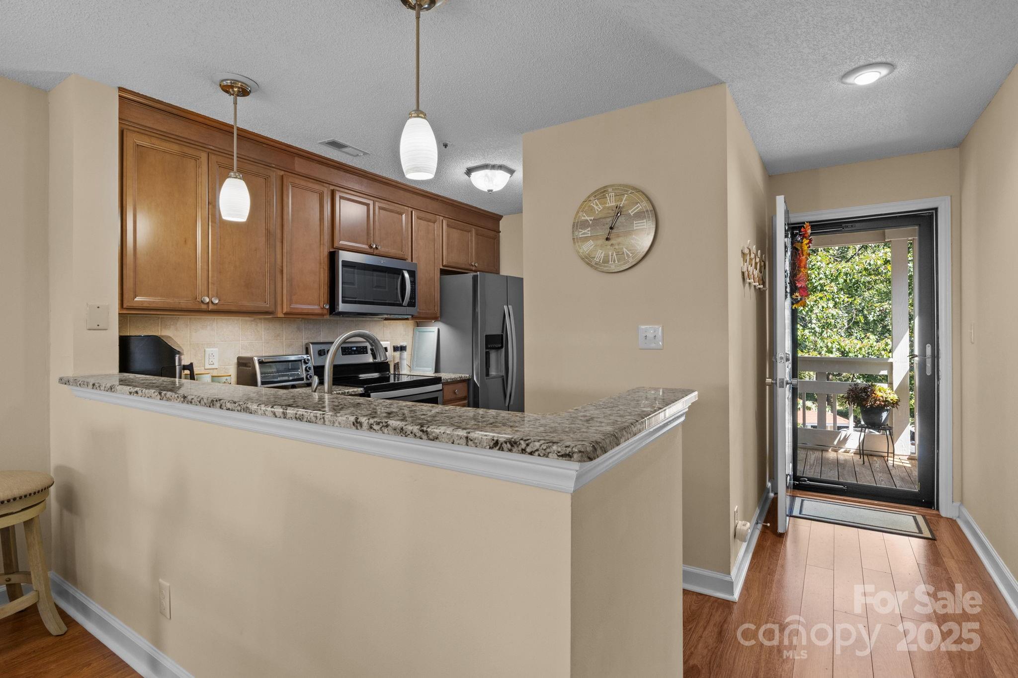 18009 Kings Point Drive, Unit I Cornelius, NC 28031 - Photo 5 of 47 a kitchen with stainless steel appliances granite countertop a sink a stove a refrigerator cabinets and a dining table