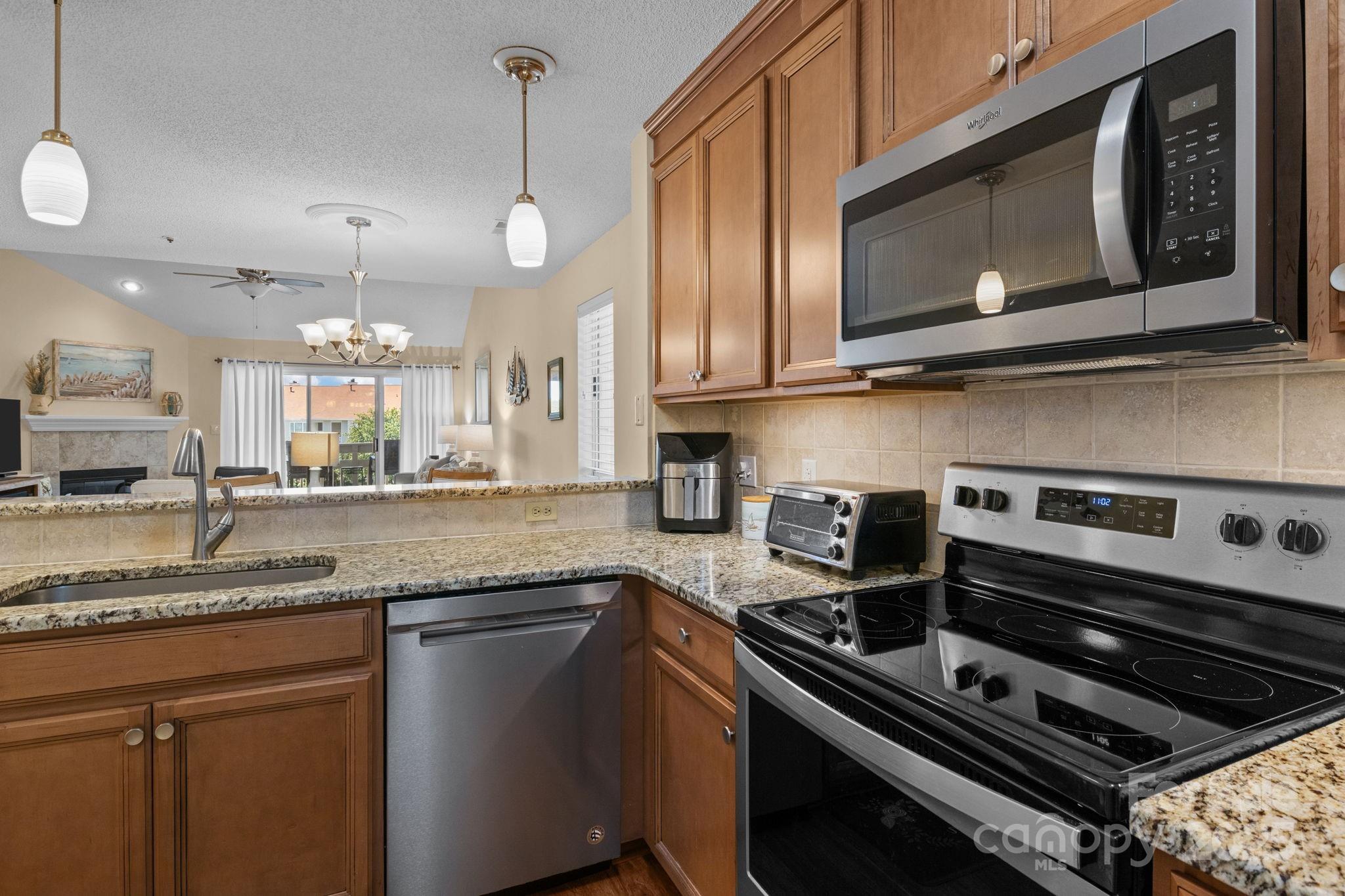 18009 Kings Point Drive, Unit I Cornelius, NC 28031 - Photo 7 of 47 a kitchen with stainless steel appliances granite countertop a stove a microwave and a sink